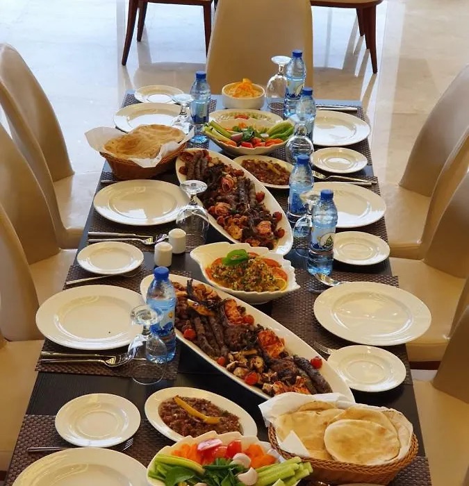 Platters of grilled meat, rice and salads on a restaurant table