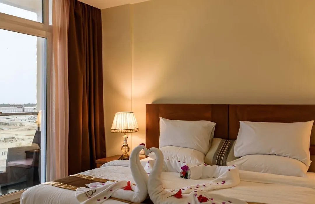 King bedroom with towel swans on the bed and a window onto the city